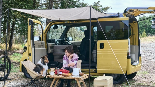 Honda N-VAN e: interior with a girl and a dog camping