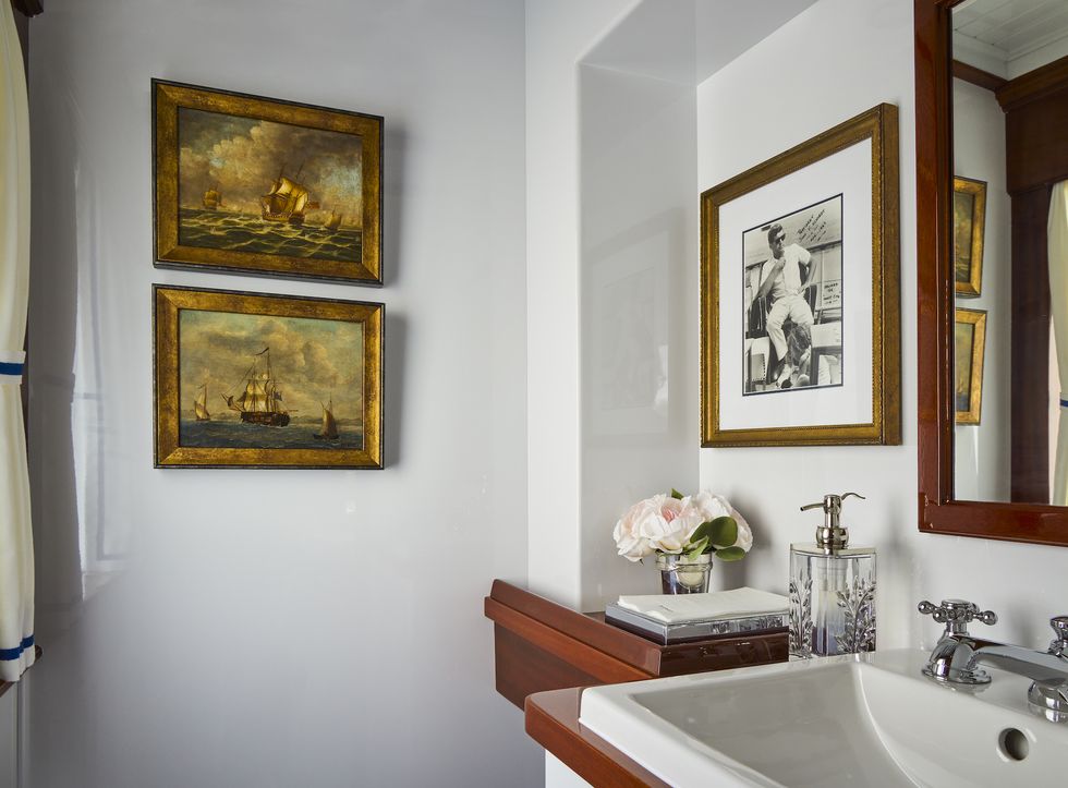 a bathroom with a sink and pictures on the wall