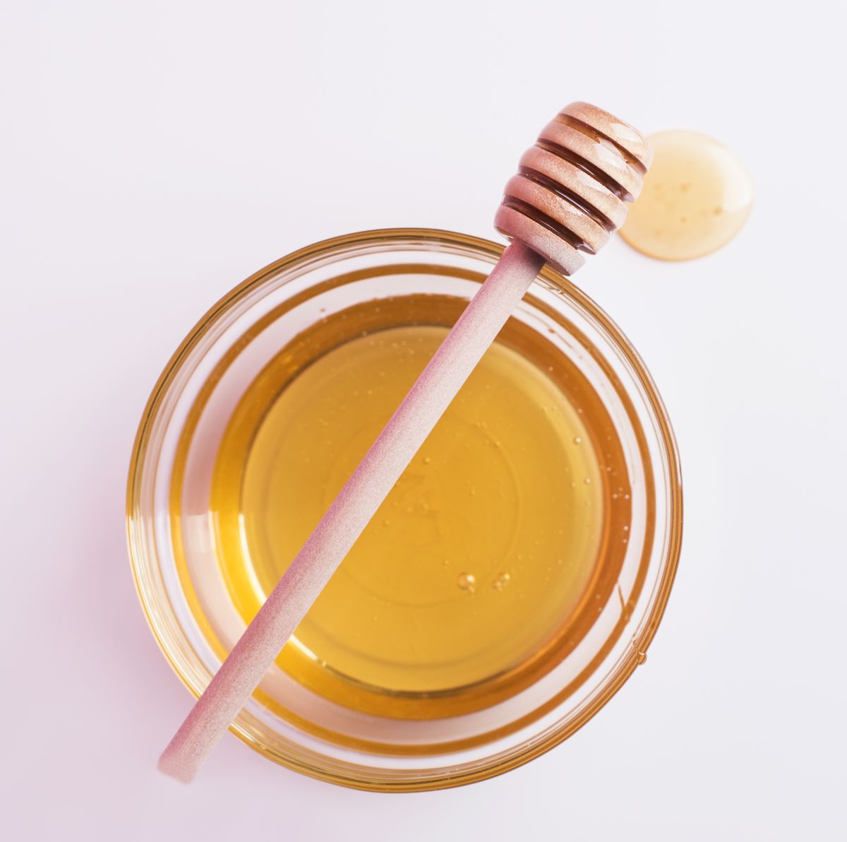 Honey spoon over glass bowl