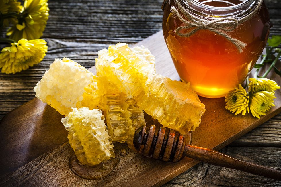 honeycomb and honey jar on rustic wooden table