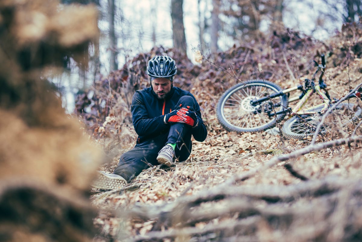 cyclist sitting on the ground after crashing his bike