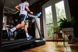 a man running on a treadmill in front of a large window