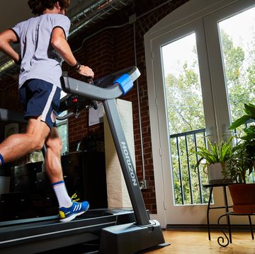 a man running on a treadmill in front of a large window