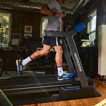 running shorts in living room on horizon folding treadmill