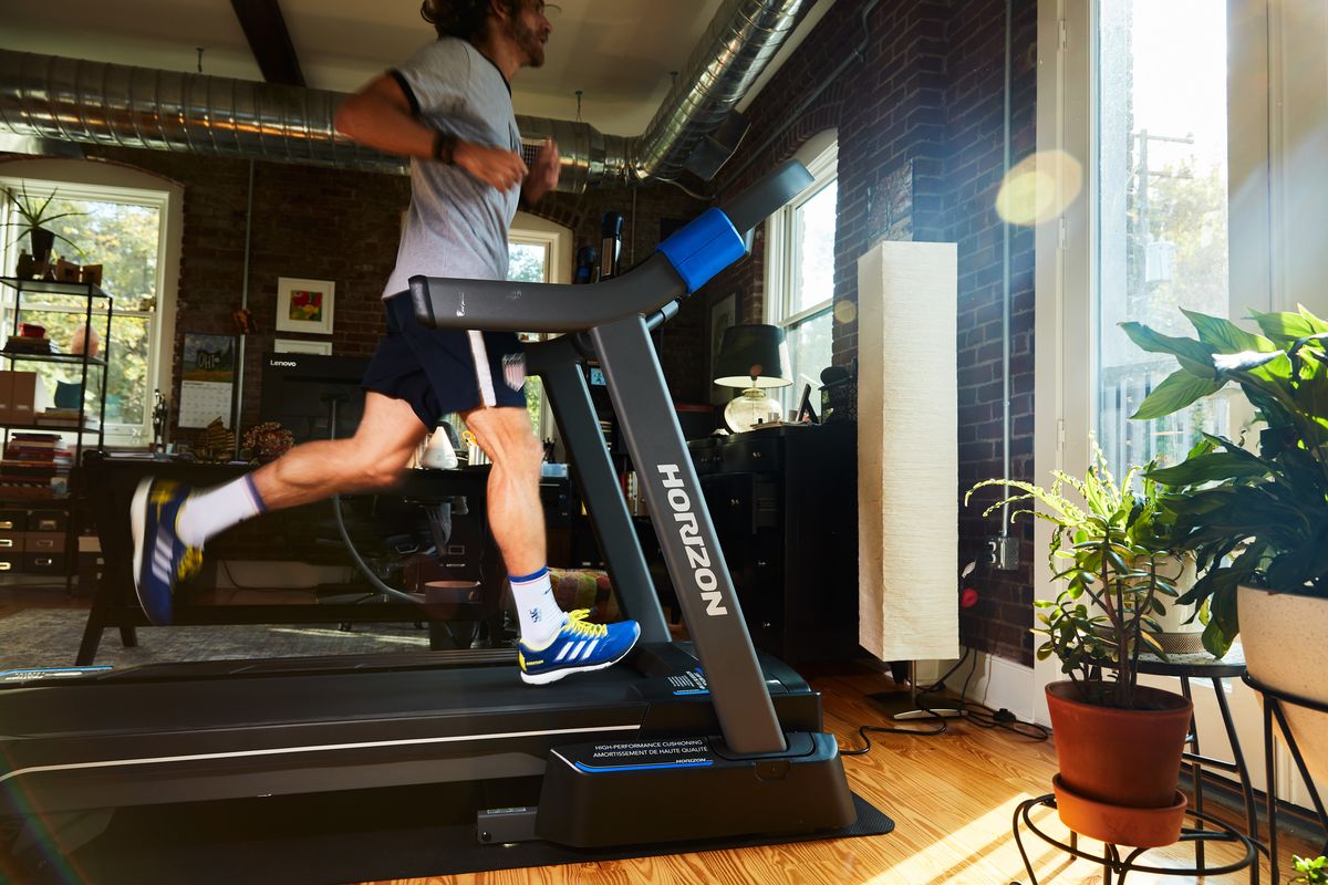 running on a treadmill in front of a bright window