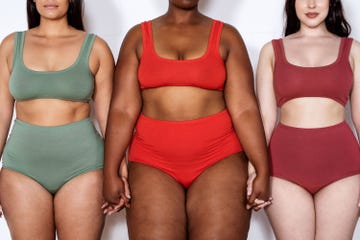 cropped shot of a three multi ethnic females of different sizes in lingerie on white background. group of plus size women in lingerie standing together holding hands.