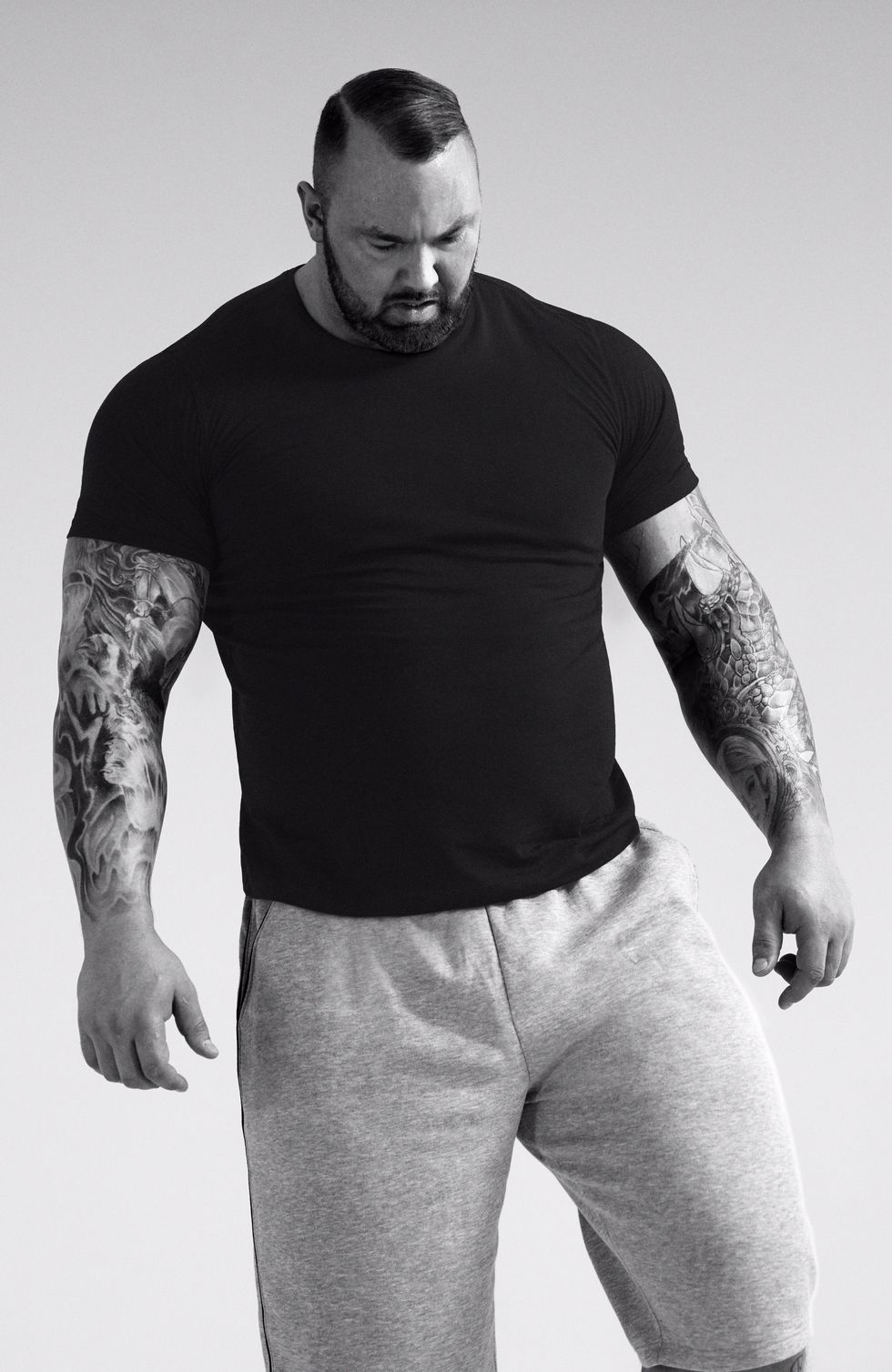 White, Black, Standing, Shoulder, Arm, T-shirt, Muscle, Facial hair, Model, Sleeve, 
