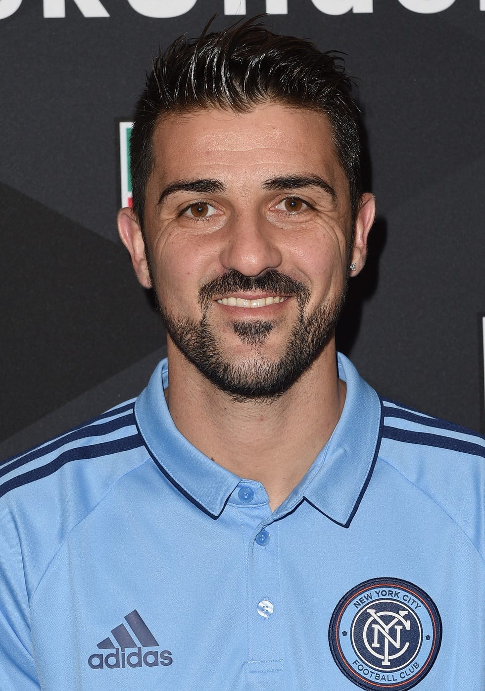 el exfutbolista david villa posando sonriendo