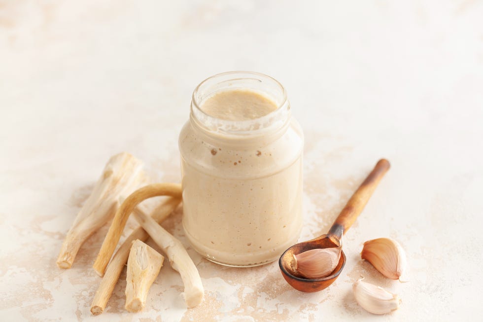 horseradish sauce in a jar and ingredients on a white background