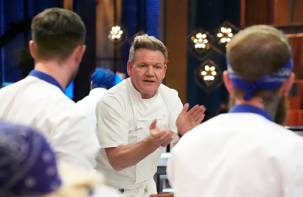 chef gordon ramsay clapping his hands as he speaks ti chefs working in a kitchen