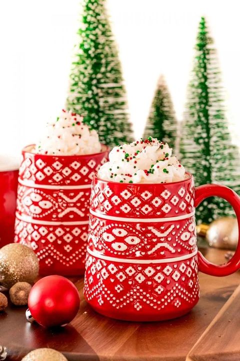 eggnog hot chocolate in red mugs with whipped cream