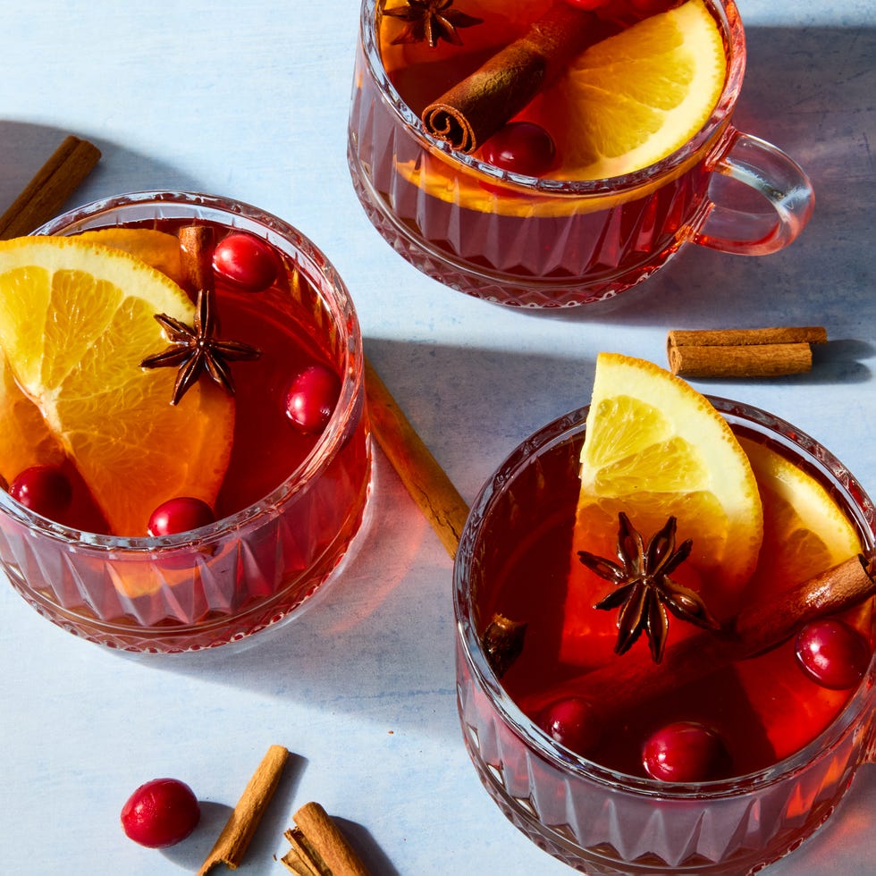 hot cocktail in a glass mug topped with cranberries and lemon