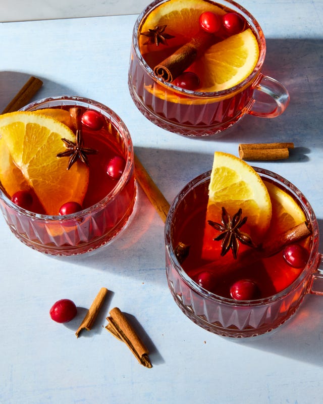 hot cocktail in a glass mug topped with cranberries and lemon