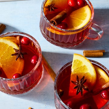 Hot Claus hot cocktail in a glass mug topped with cranberries and lemon
