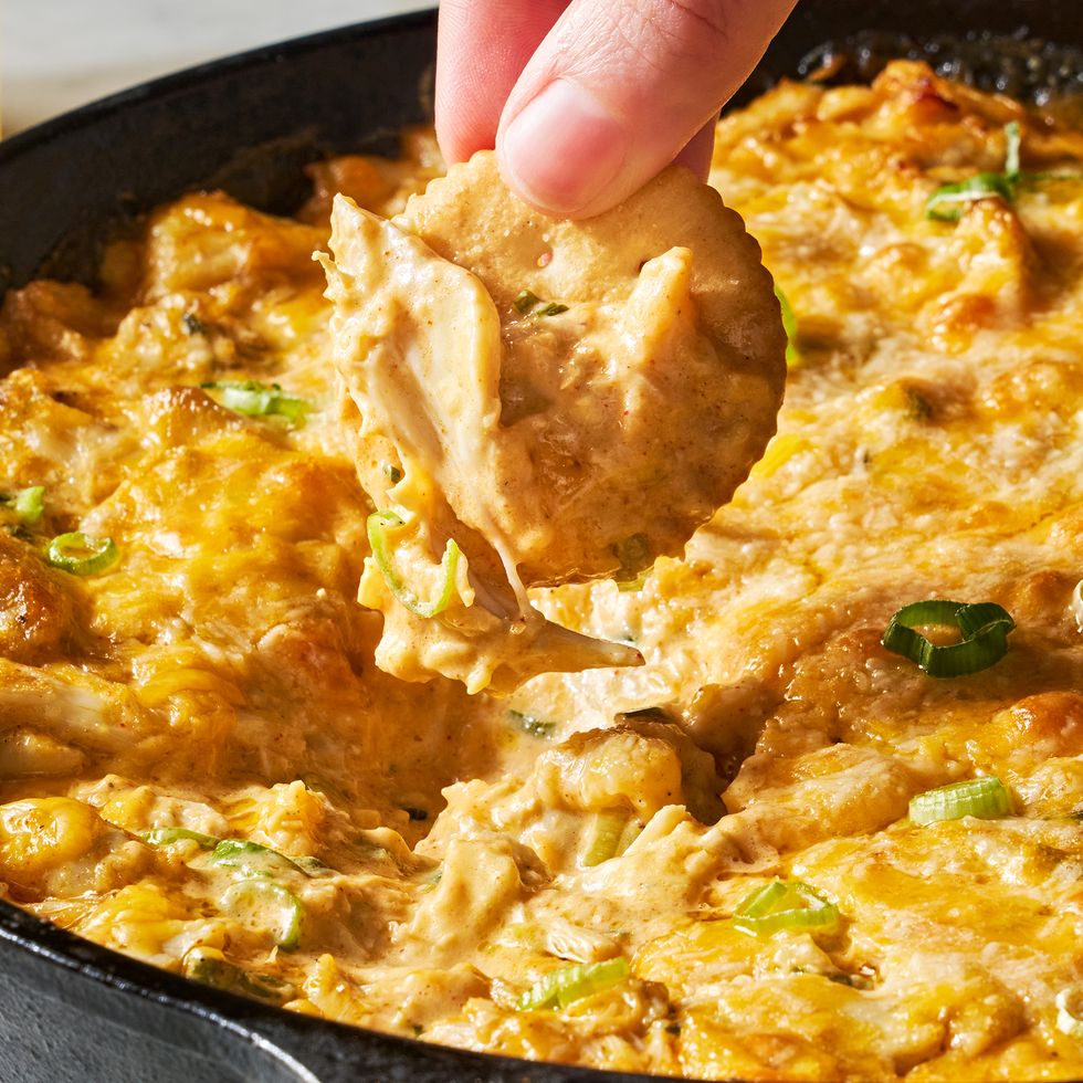 hot crab dip in a cast iron skillet served with crackers