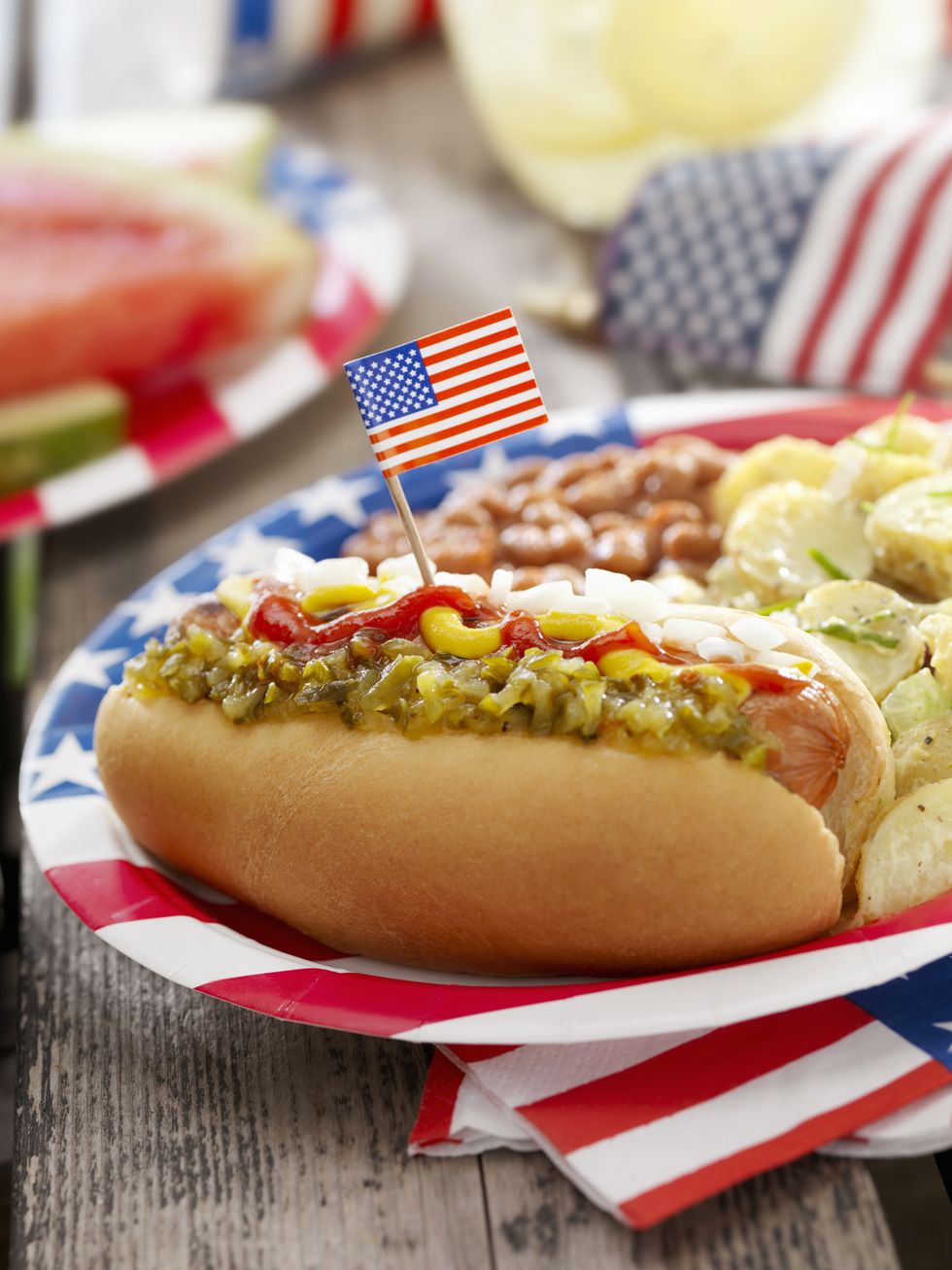 bbq hotdog with mustard, ketchup, relish and onions with potato salad and baked beans at a 4th of july picnic  photographed on hasselblad h3d2 39mb camera