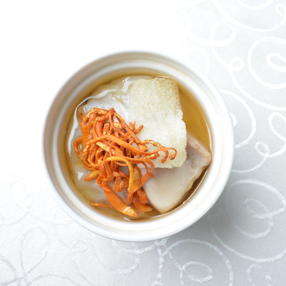 hot double boiled chicken soup with herbal cordyceps flower pot in white background asian halal menu