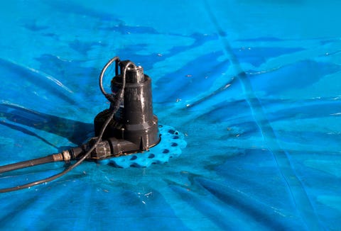 automatic pool cover pump on top of blue wet cover perspective view of black pool cover pump for keeping the water away from pool covers or spas dir