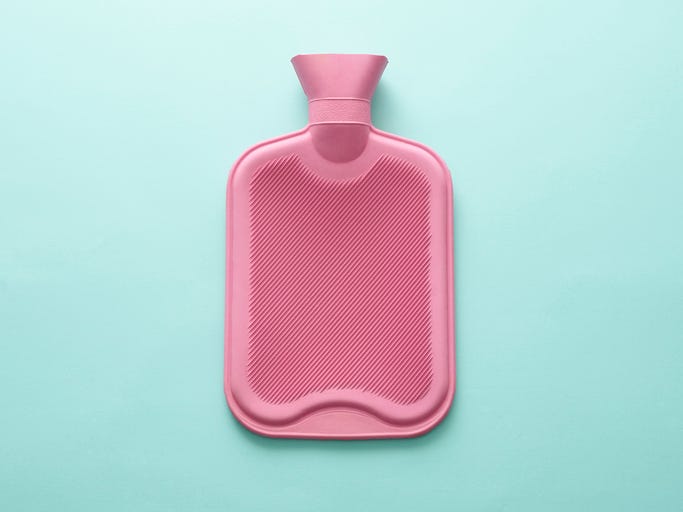 pink hot water bottle on blue background