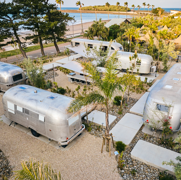 a group of rvs parked on a dirt road by a body of water