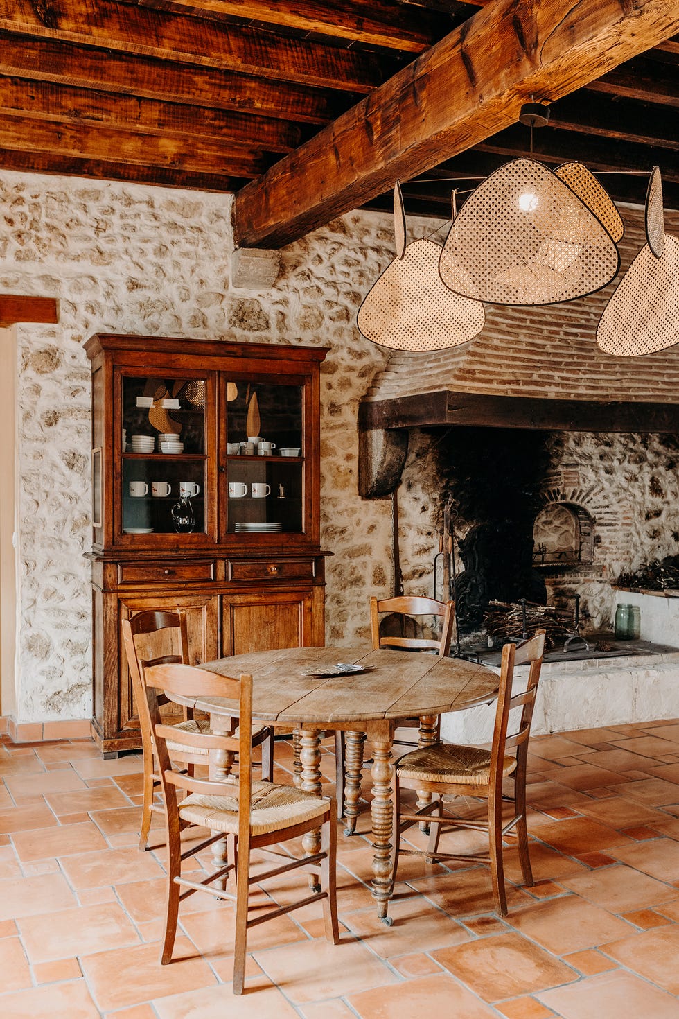 salón comedor rústico con paredes de piedra y muebles de madera antiguos