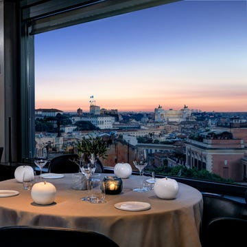 a table with plates and glasses on it with a view of a city