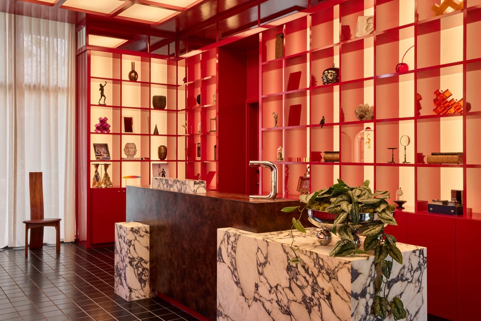 lobby with red laquered shelves backed with lights and black floor tiles
