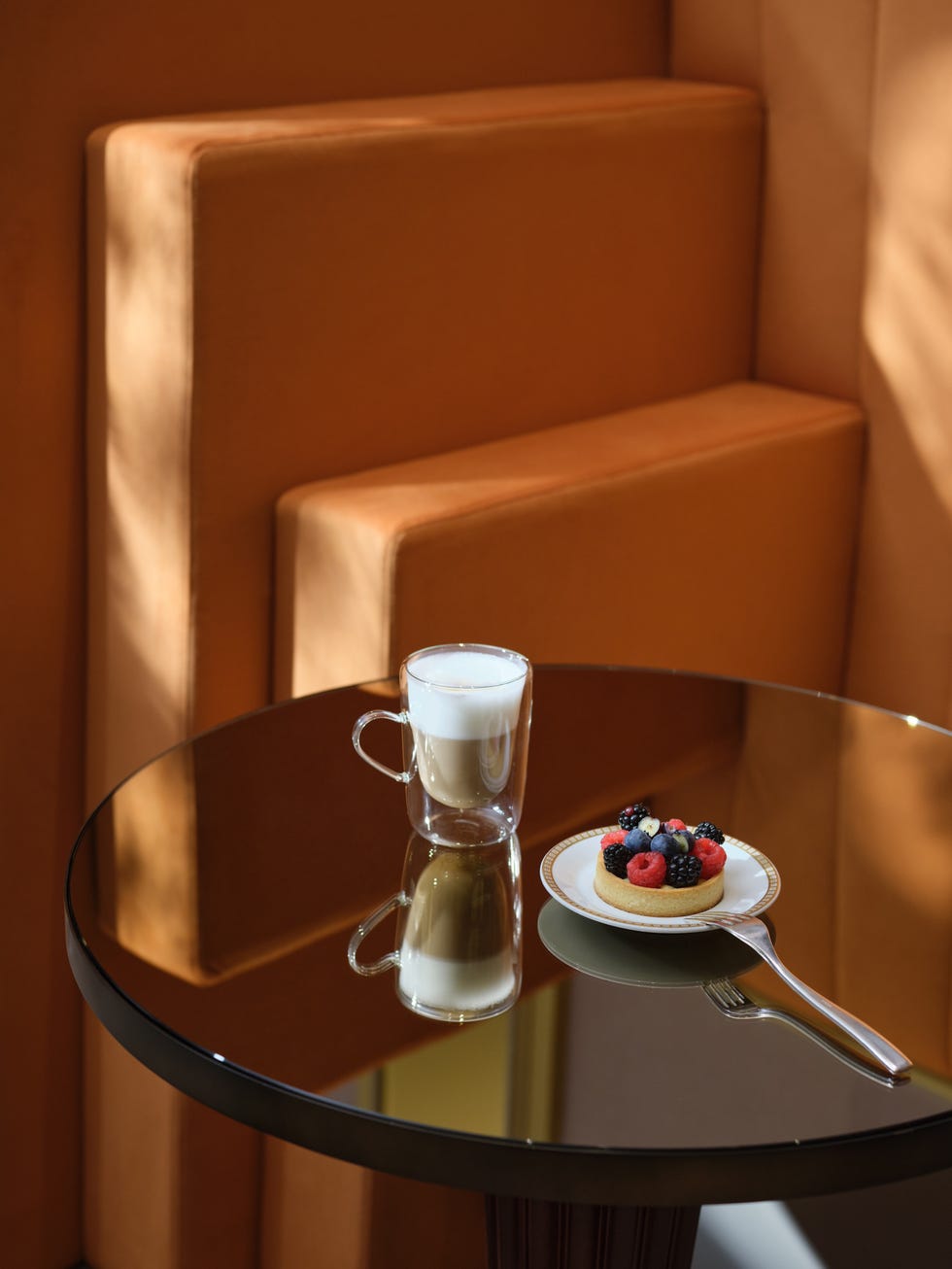 a dessert and coffee placed on a reflective table