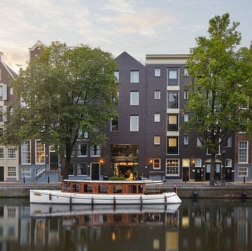 Hotels Amsterdam City Centre - Pulitzer Amsterdam pulitzer amsterdam facade with trees and a boat in the water