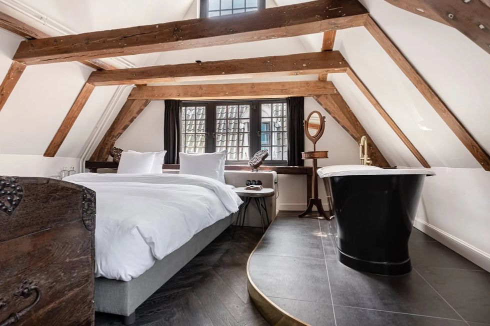a loft bedroom with a bed and a bathtub