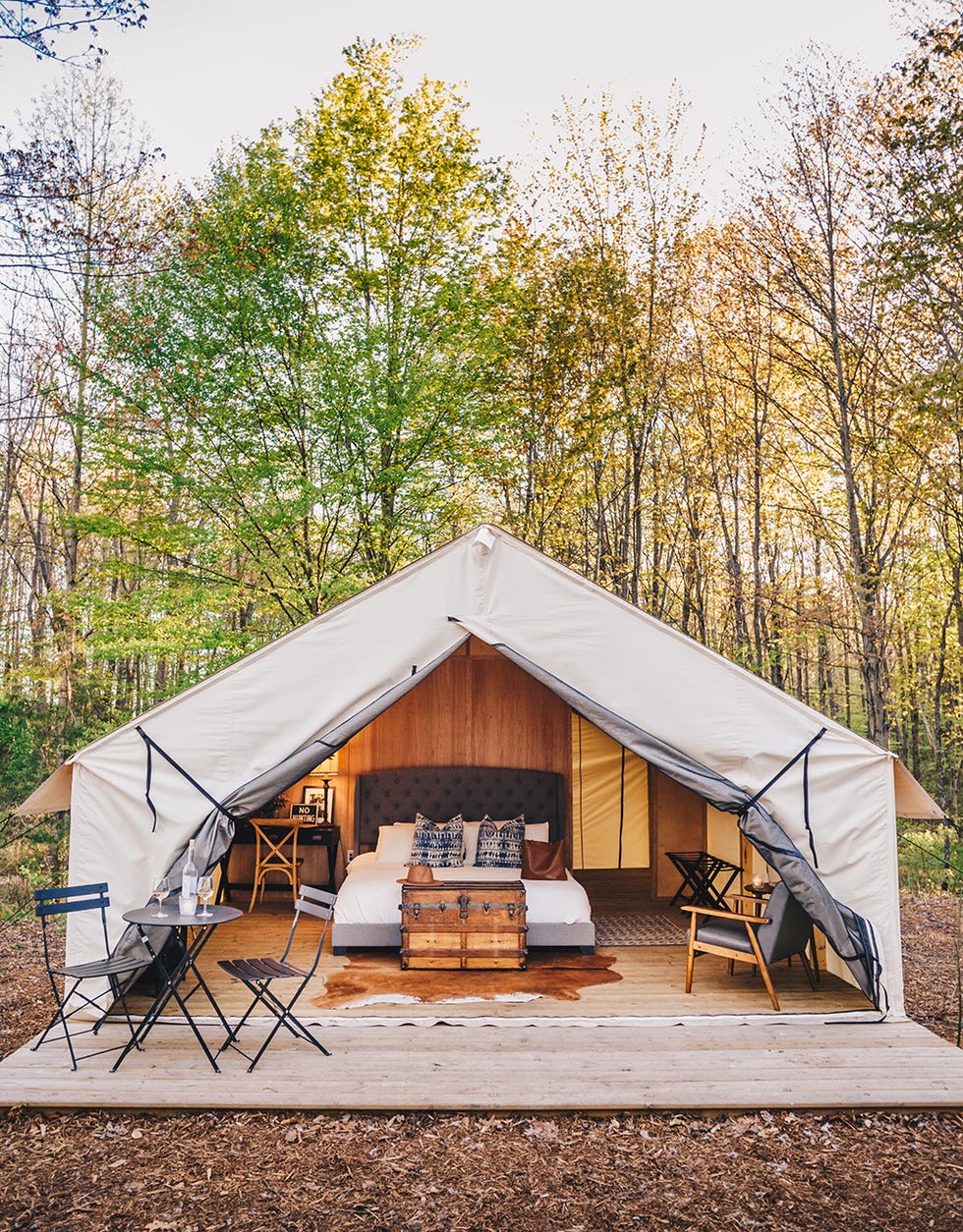 glamping tent with bed and bistro table set at the fields of michigan in southhaven mi