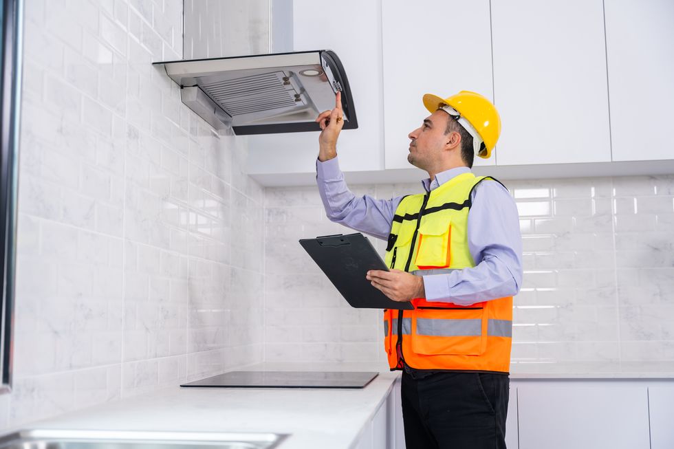 a house inspector checking a quality of the kitchenware in a new house