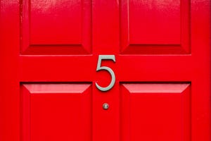 house number 5 on a red wooden front door in london