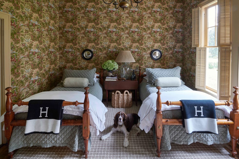 belgian flax linen quilts cover a pair of twin beds that both sam and his father slept in as children and the small convex mirrors are by oka and the check rug is by fibreworks