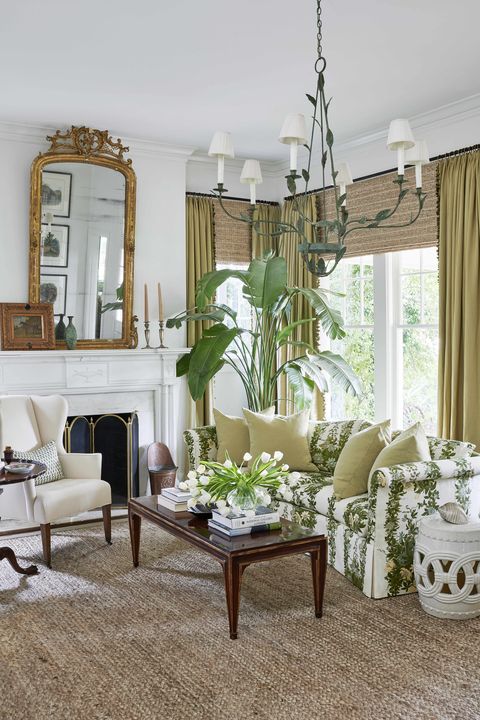 in the living room the sofas leafy pattern and a vine sculpted tole chandelier relax wingback chairs and a gilded french mirror