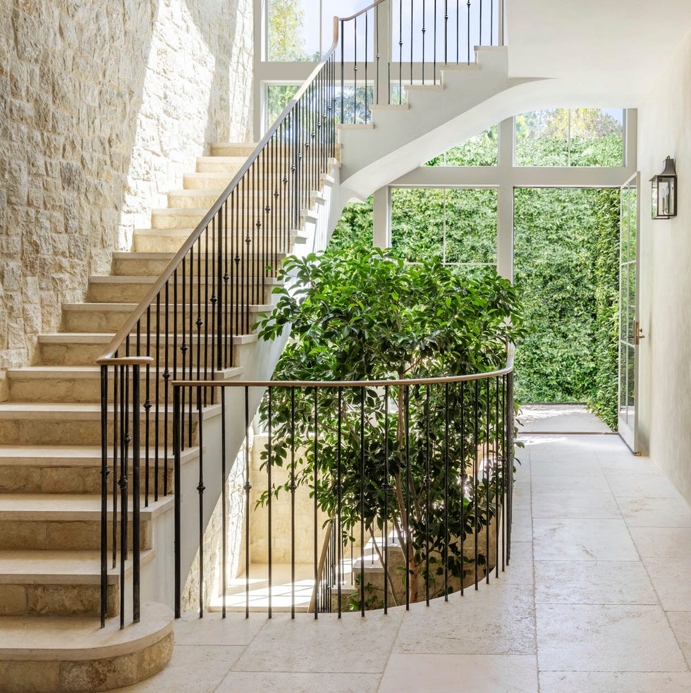 double story glass and steel windows send sunlight streaming into the stairwell including the basement level