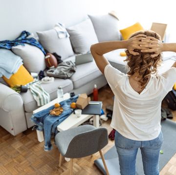 housewife at modern home on sunny day looking at dirty room.