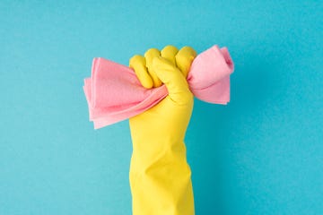 housework chore wars yellow gloved hand holding pink cloth on blue background