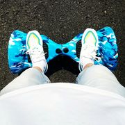 man looking down at blue camo hoverboard