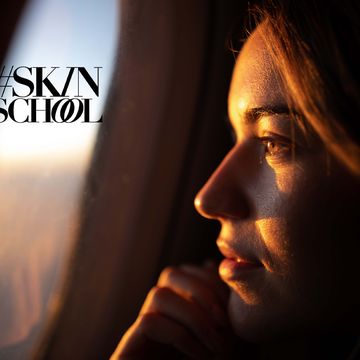 close up of young woman day dreaming while looking through an airplane window at sunset