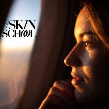 close up of young woman day dreaming while looking through an airplane window at sunset
