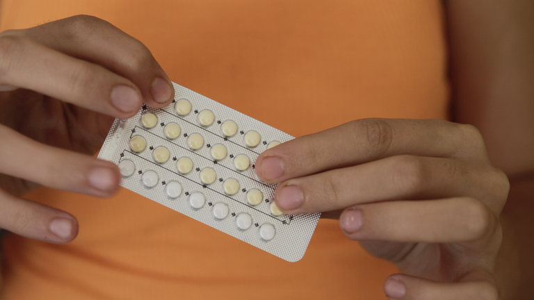 a person holding the contraceptive pill