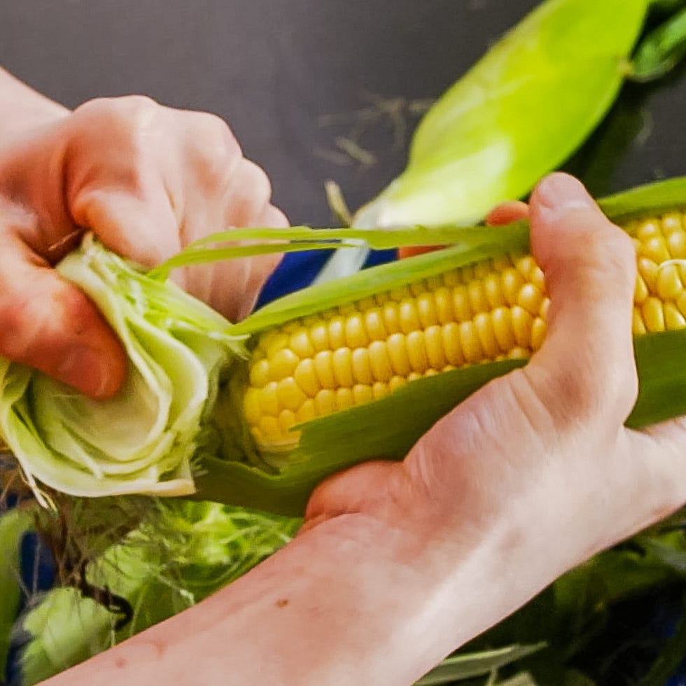 a person shucking corn