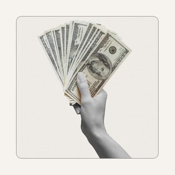 a hand holding a fan of paper money