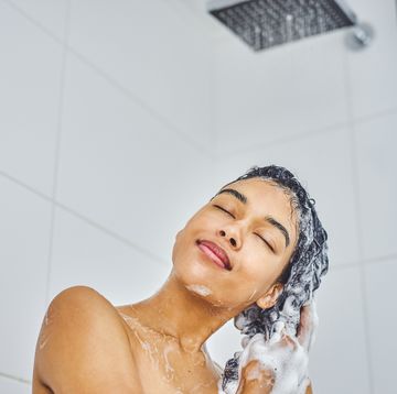 african american woman shampooing her hair in the shower