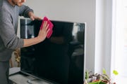 close up of man cleaning tv screen