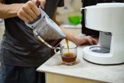 a man making coffee with drip coffee maker