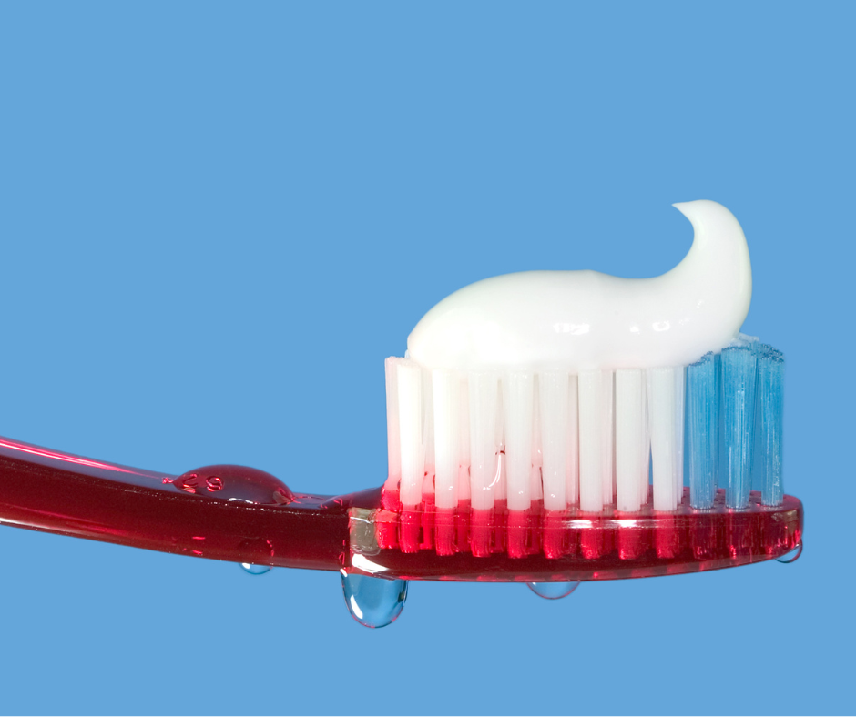 toothbrush with toothpaste on bristles against a blue background