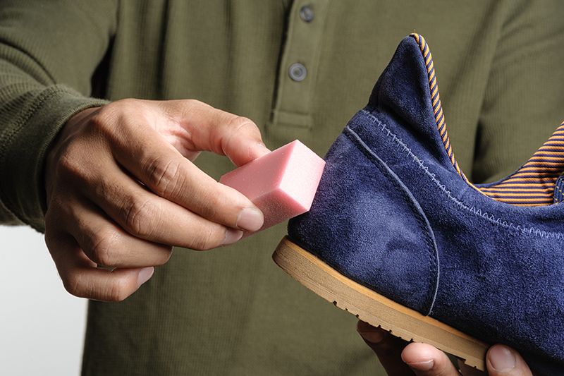 cleaning suede trainers using an eraser to remove stubborn stains from the surface