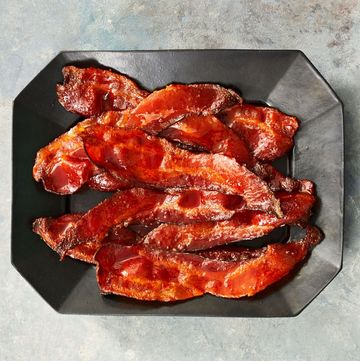 cooked sriracha maple bacon on a black serving plate